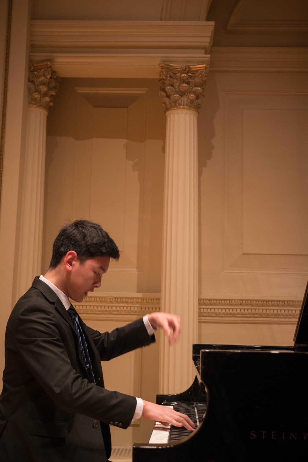 Close, mid-phrase, the right hand lifted above the keys